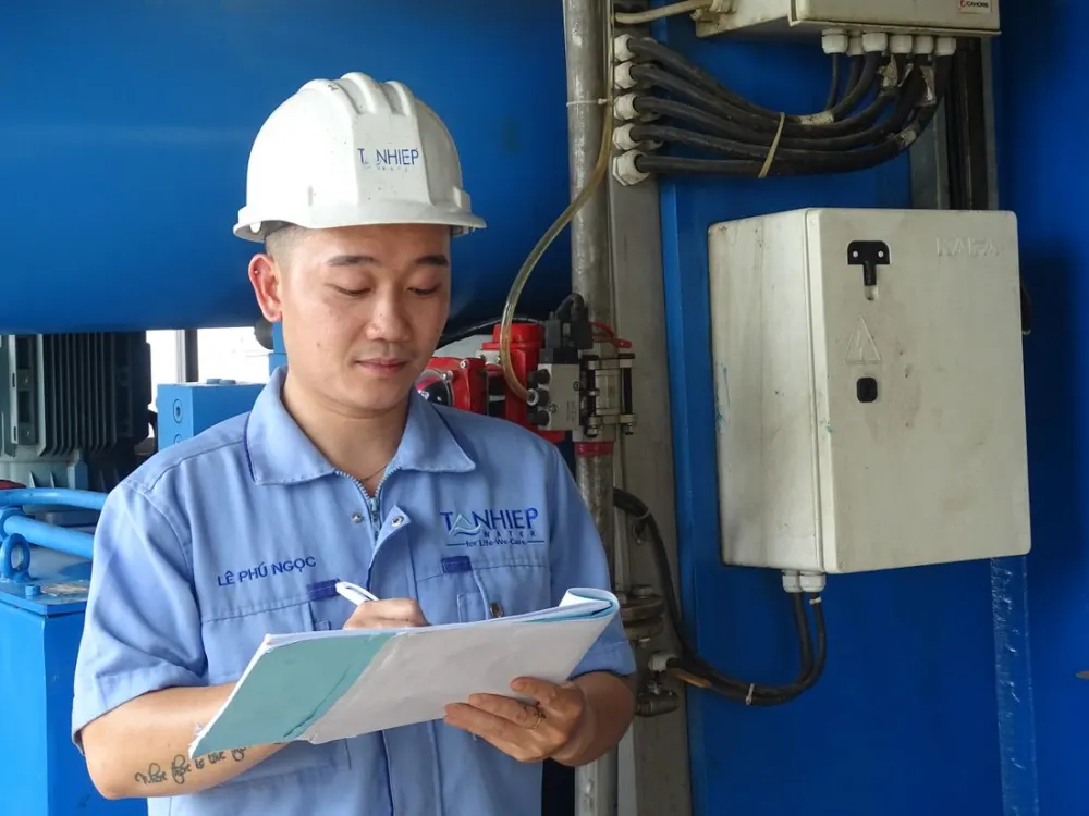 Engenheiro registrando dados durante avaliação em planta industrial