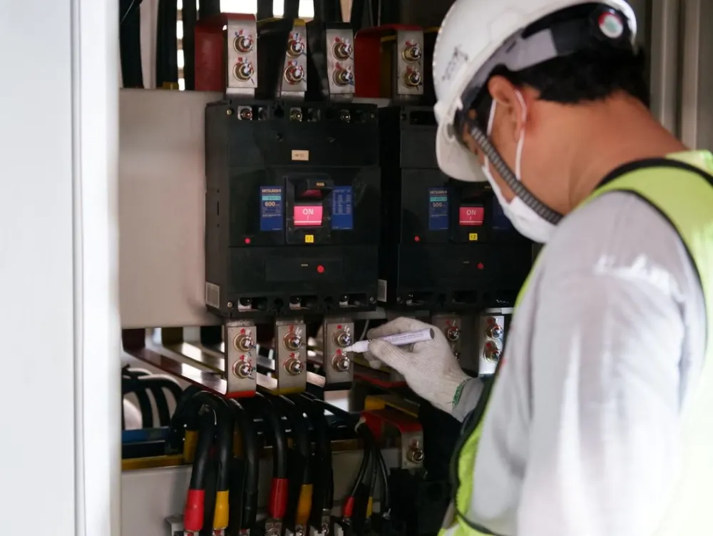 Técnico inspecionando painel elétrico industrial